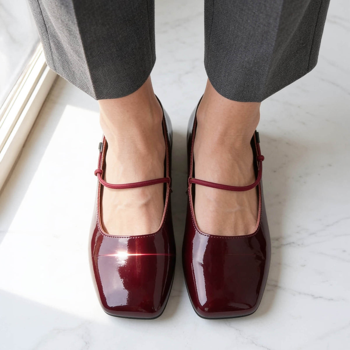 Empress Australia Square Toe Flat in patent wine. square toe detail, top view, women's quiet luxury 
flat shoe on marble floor